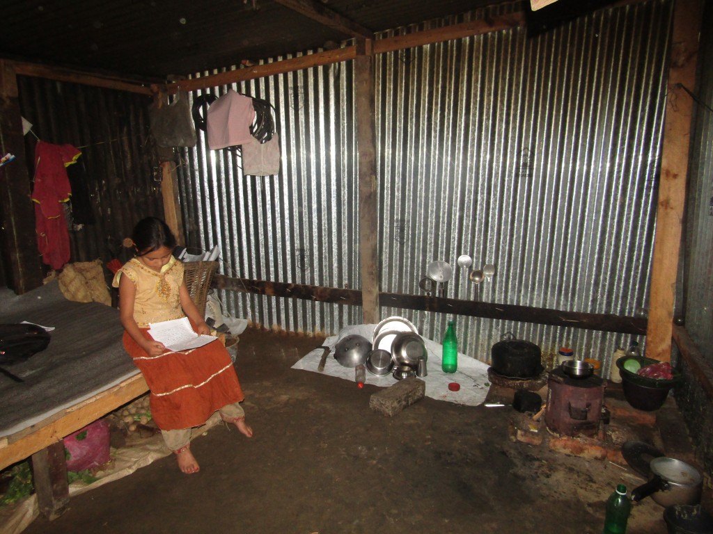 Nine-year-old Sita sits in her house, afraid to play outside after the earthquake.