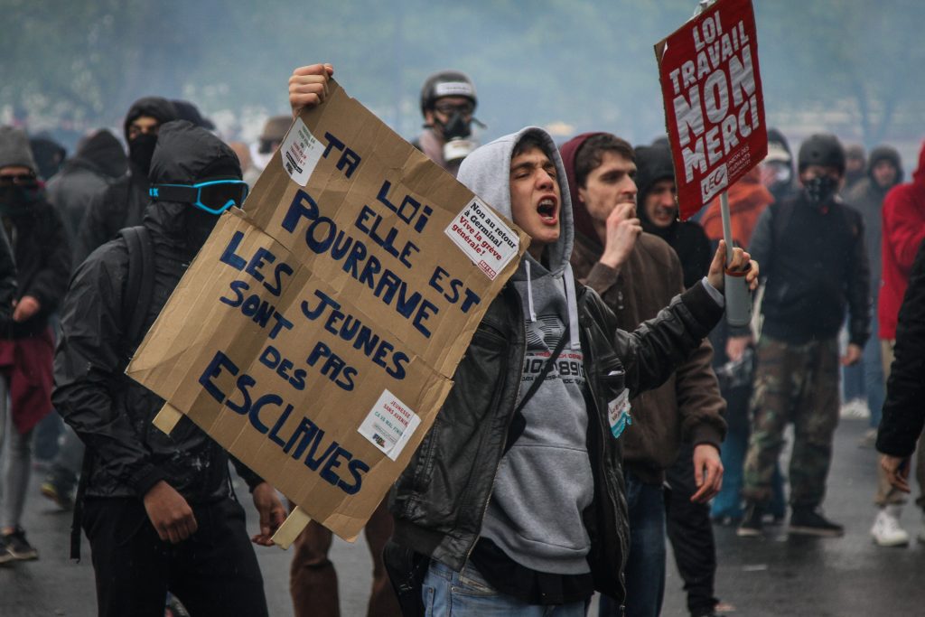 Young protester holding a banner "The Law is rotten. Young people are not slave", Paris. ©Edouard Richard 